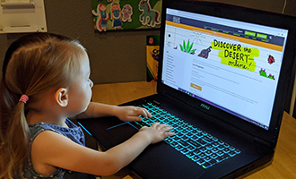 Young Girl using laptop to view online programming