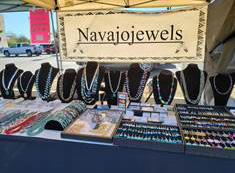 Jewelry display on a table with Navajo jewels banner above