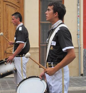 2 men playing marching band drums on the street in Spain 