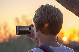 Photographer focusing camera on sunset
