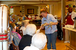 Educator Catherine shows a gopher snake to a group of older adults
